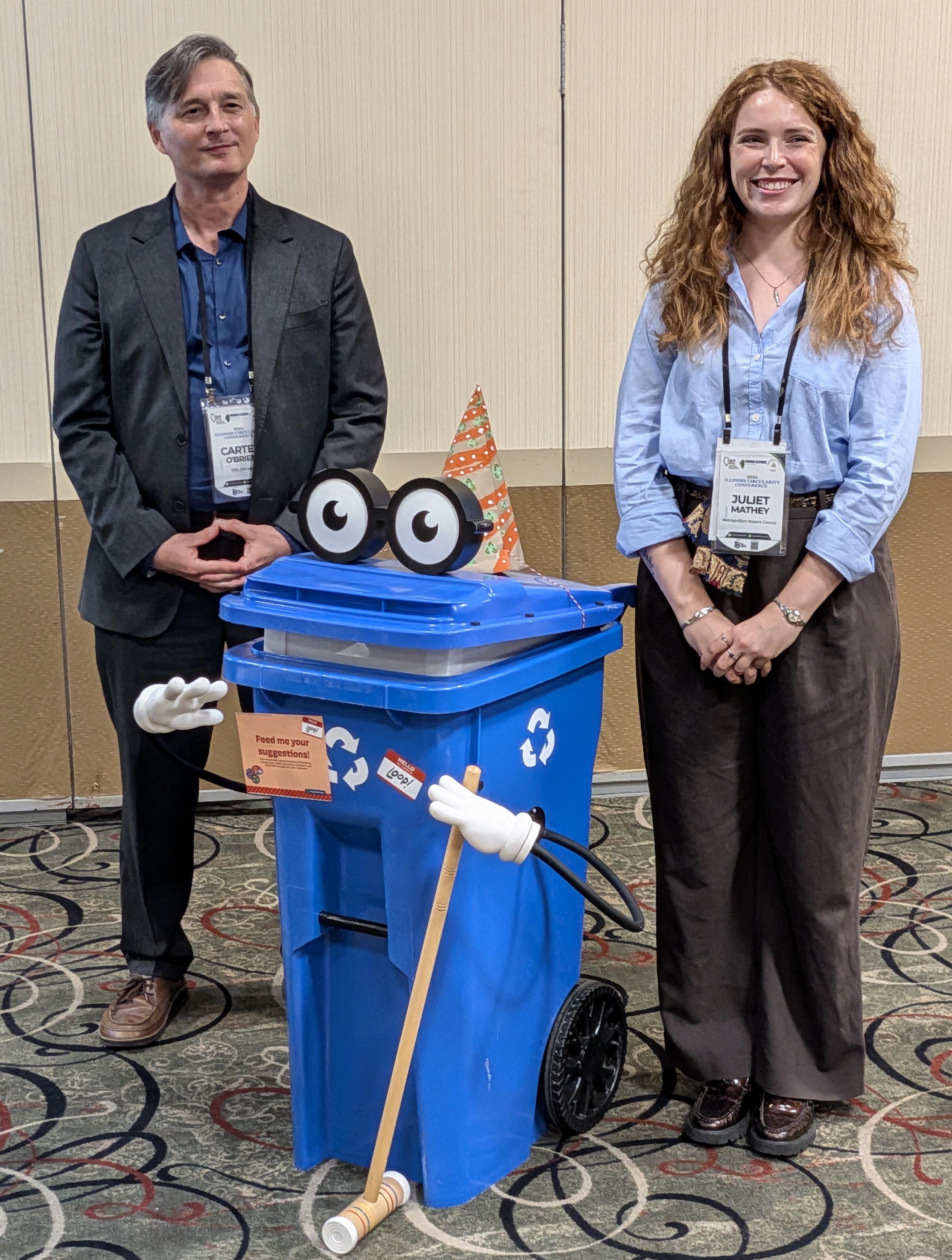Carter O'Brien and Juliet Mathey standing with Loop the recycling cart